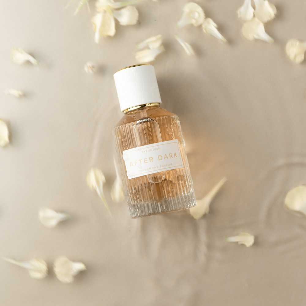 Eye of Love After Dark perfume 50ml bottle styled with flowers